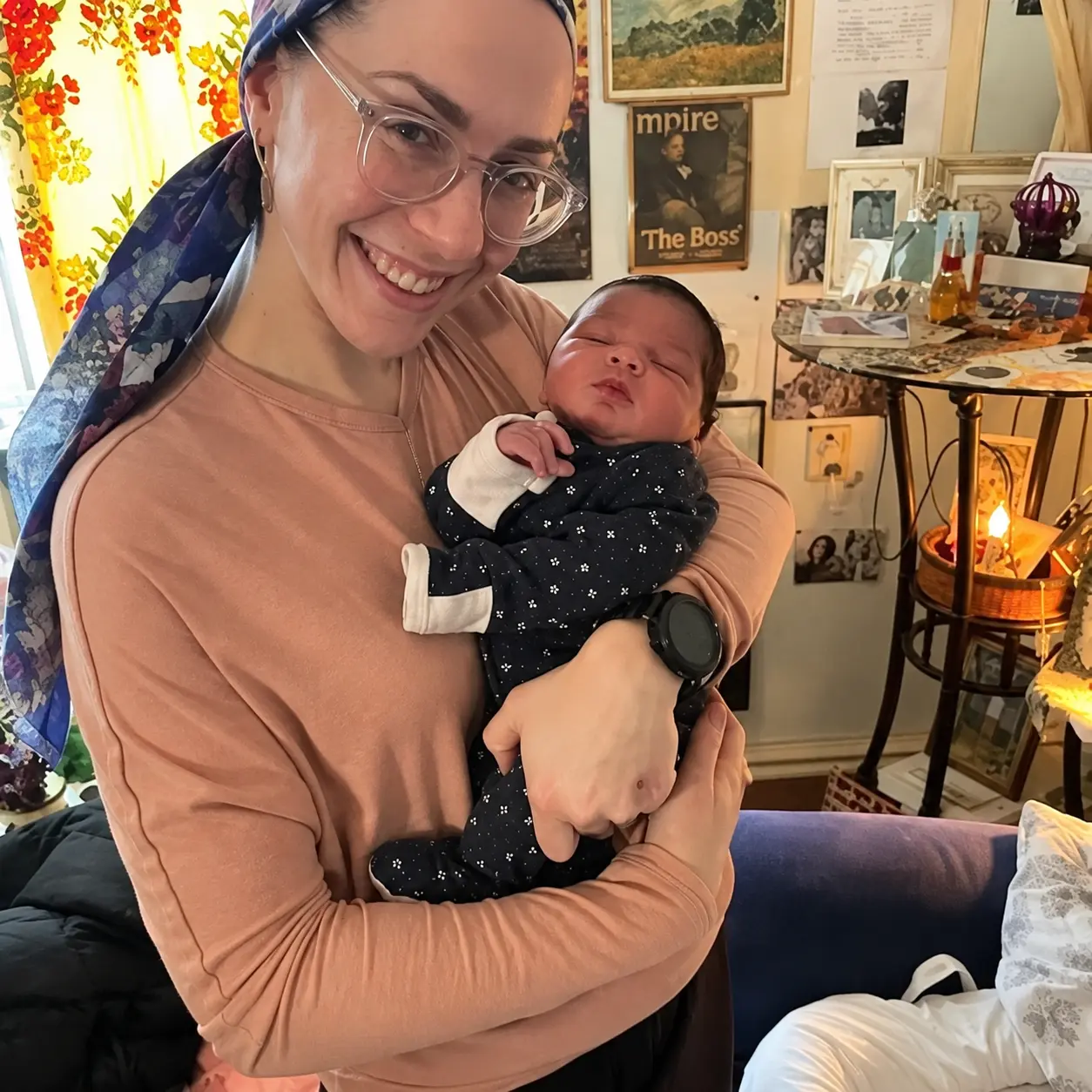 Malki Schuler, MSN, CNM, C-EFM, LCCE, holding a sleeping newborn
